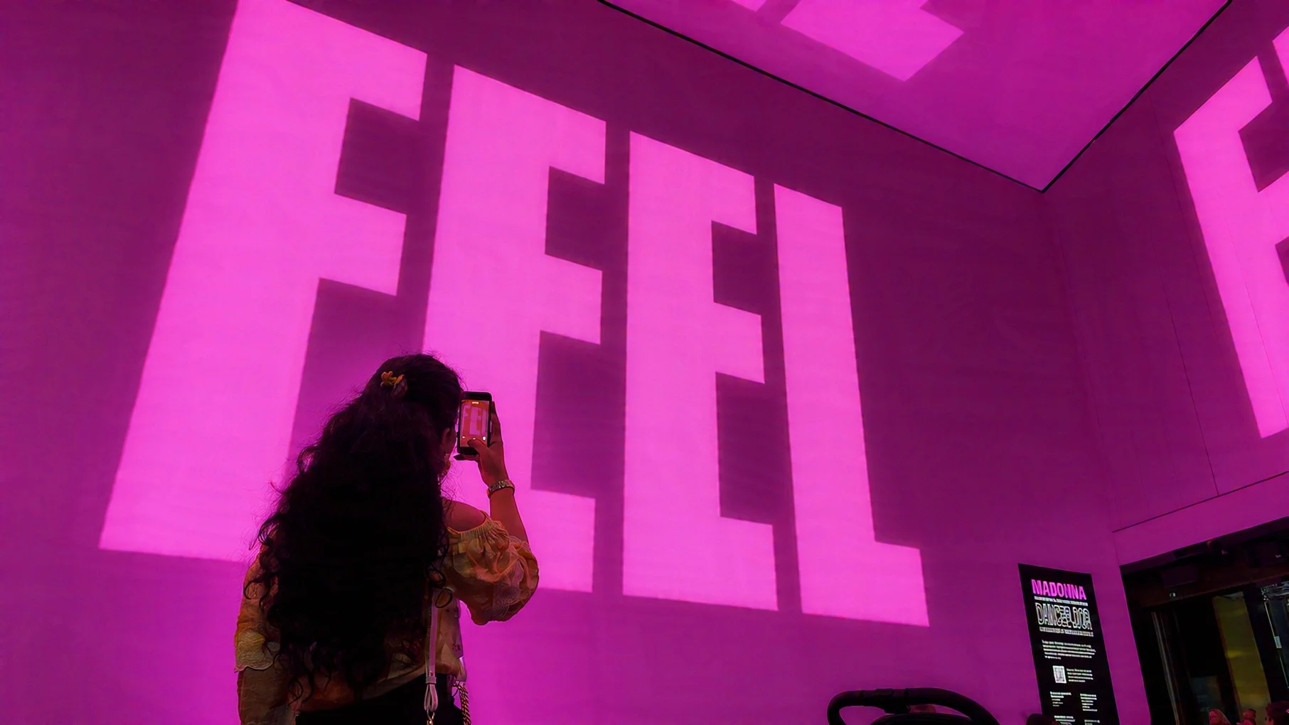 A visitor photographs the pink I Feel So Free visuals.